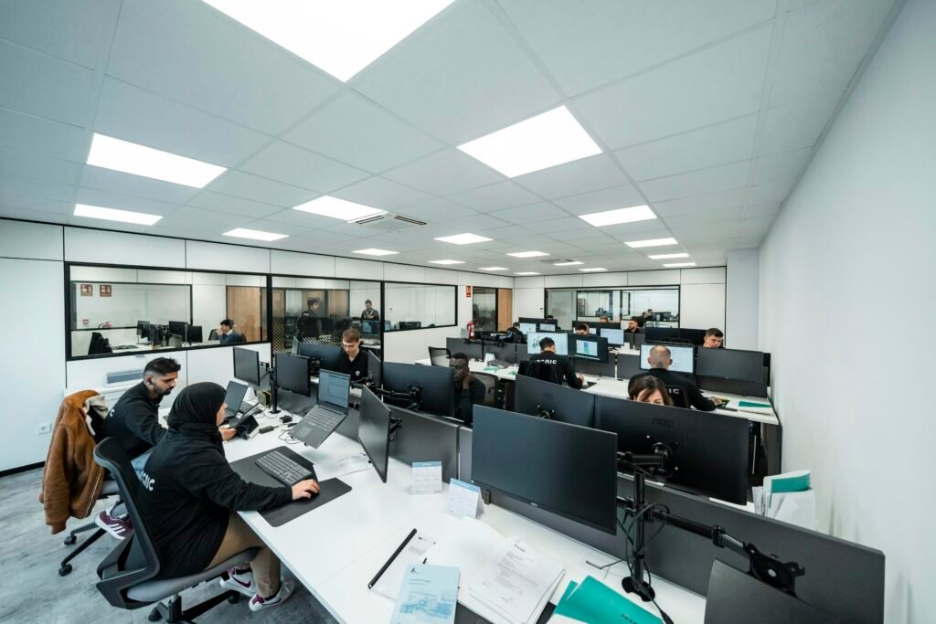 Mehrere Büroangestellte arbeiten konzentriert an ihren Computern in einem modernen Großraumbüro