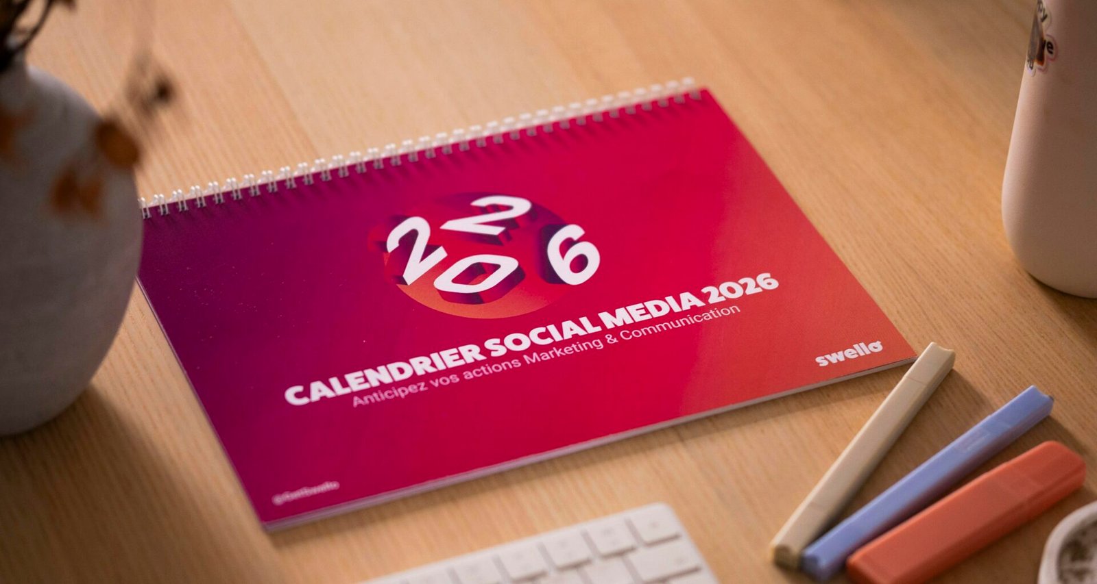 Ein Schreibtisch mit einem offenen Kalender für das Jahr 2016, der für die Social Media Planung genutzt wird.
