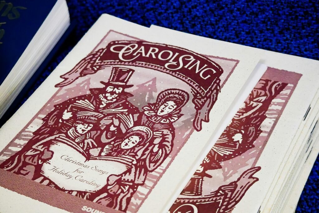 Nahaufnahme eines Carol-Singbuchs mit klassischen Vintage-Illustrationen und Liedtexten