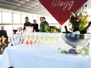 Mehrere Champagnergläser und Flaschen stehen auf einem Tisch und sorgen für festliche Atmosphäre bei einem Event.