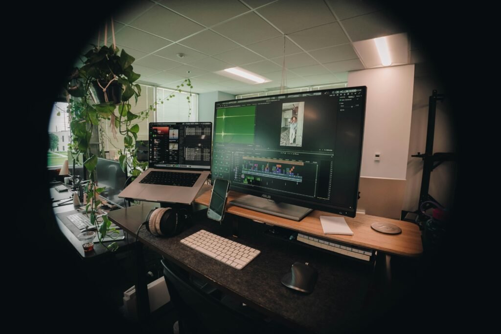 Moderner Arbeitsplatz mit mehreren Bildschirmen, Computer und dekorativen Pflanzen für eine produktive Umgebung