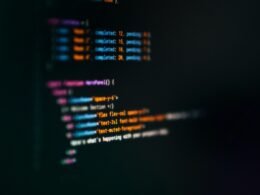 Computerbildschirm mit zahlreichen, farbig hervorgehobenen Code-Zeilen und Programmieroberfläche.