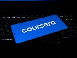 Das Coursera Logo erscheint auf dem Display eines Laptops, aufgenommen aus der Nähe mit Fokus auf die Tastatur.
