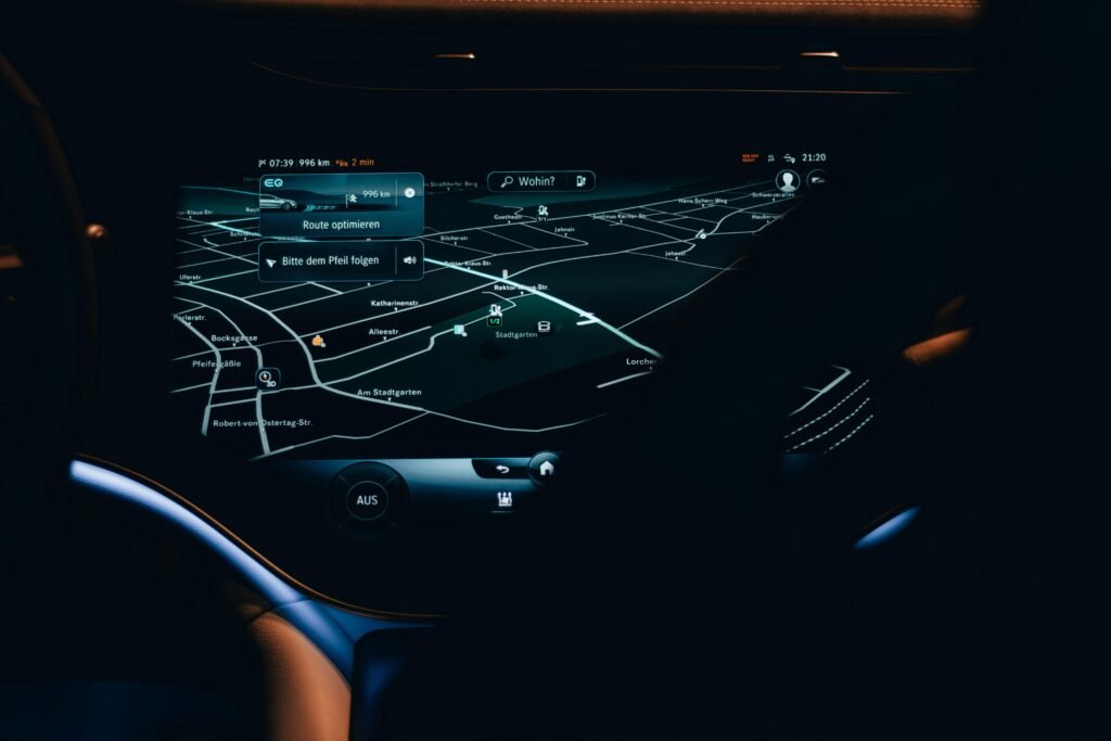 Nahaufnahme eines Autofahrer-Cockpits mit integrierter digitaler Karte und Navigationssystem auf dem Display.