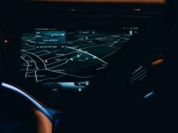 Nahaufnahme eines Autofahrer-Cockpits mit integrierter digitaler Karte und Navigationssystem auf dem Display.