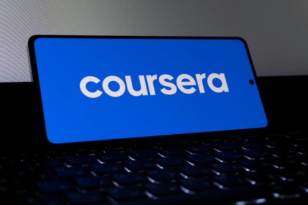 Das Coursera-Logo wird auf einem Smartphone-Bildschirm angezeigt, fotografiert aus der Nähe als Symbol moderner Online-Kurse.