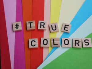 Das Wort 'true colors' ist mit Scrabble-Buchstaben auf einer hellen Oberfläche ausgelegt
