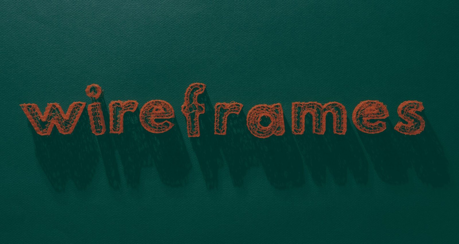 Der Schriftzug 'wireframes' ist auf eine grüne Oberfläche geschrieben und steht symbolisch für digitale Designkonzepte.