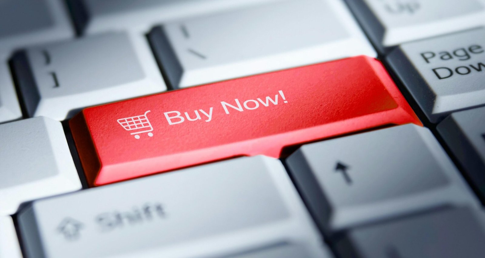 Roter 'Buy Now!' Button auf einer weißen Computertastatur als Symbol für Online-Shopping und E-Commerce