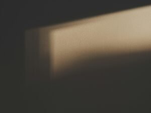 Der Schatten eines rechteckigen Fensters fällt klar erkennbar auf eine helle Wand in einem Innenraum.