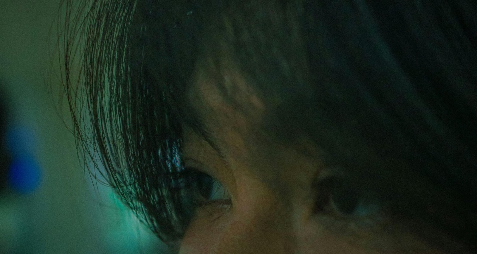 Nahaufnahme von konzentrierten Augen, die in gedämpftem Licht auf einen Punkt gerichtet sind