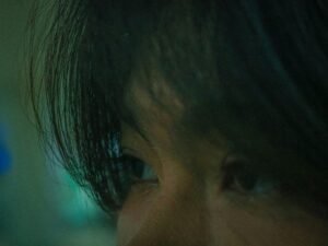 Nahaufnahme von konzentrierten Augen, die in gedämpftem Licht auf einen Punkt gerichtet sind