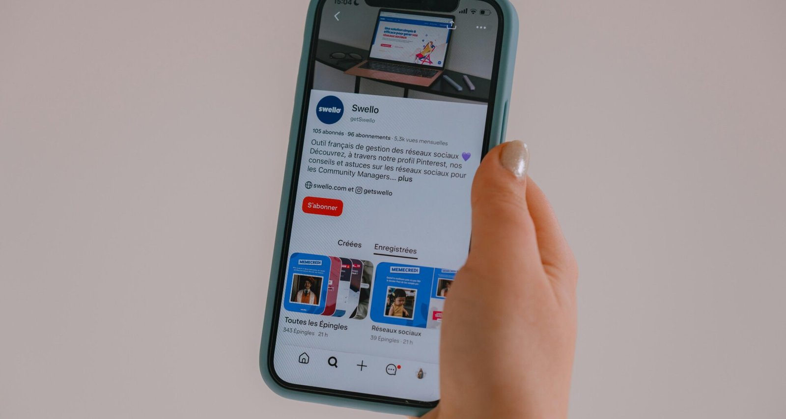 Hand hält ein Smartphone, auf dessen Bildschirm ein Social Media Feed dargestellt wird, Fokus auf moderner digitaler Kommunikation