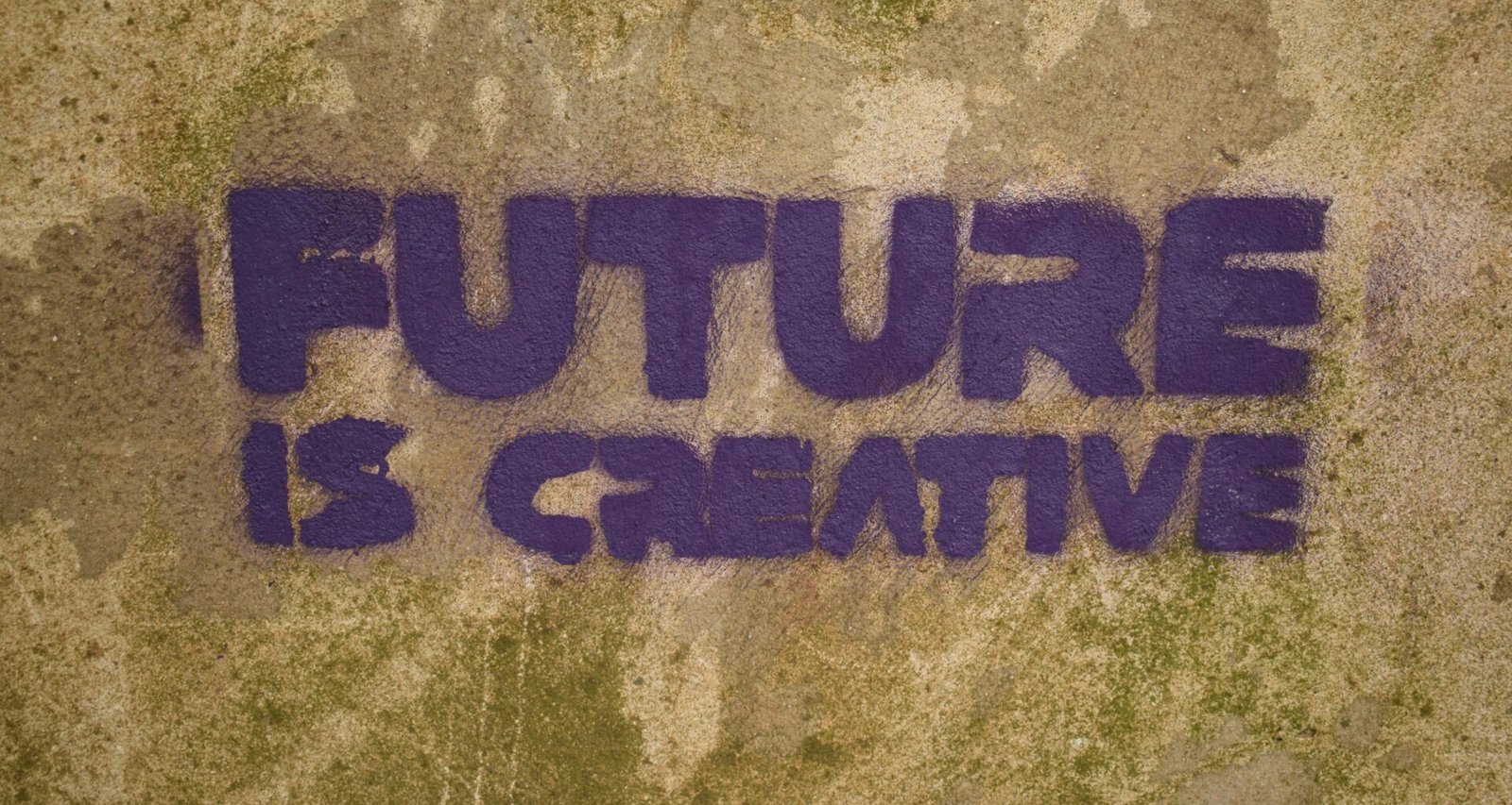 Auf einer Wand steht in großen Buchstaben der Spruch 'future is creative' aufgemalt – Symbol für innovative Ideen.
