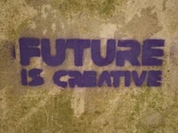 Auf einer Wand steht in großen Buchstaben der Spruch 'future is creative' aufgemalt – Symbol für innovative Ideen.