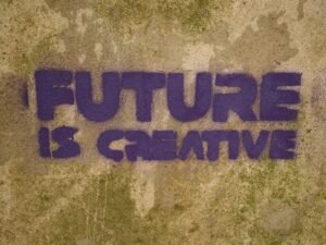 Auf einer Wand steht in großen Buchstaben der Spruch 'future is creative' aufgemalt – Symbol für innovative Ideen.