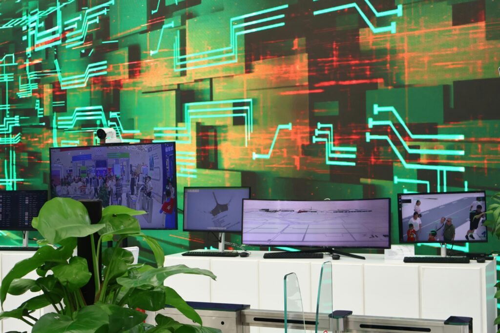 Digitale Bildschirme zeigen verschiedene Daten auf einem Hintergrund mit Leiterplatten und elektronischen Komponenten.