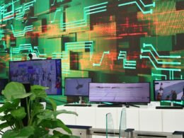 Digitale Bildschirme zeigen verschiedene Daten auf einem Hintergrund mit Leiterplatten und elektronischen Komponenten.