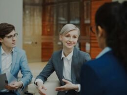 Drei Geschäftsleute diskutieren gemeinsam Dokumente während eines Meetings in einem modernen Büro.