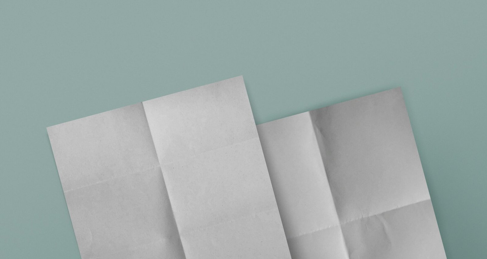 Drei weiße Papierblätter auf strukturiertem, blauem Hintergrund, angeordnet für einen klaren, minimalistischen Look.