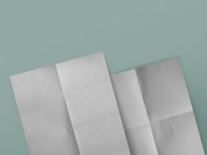 Drei weiße Papierblätter auf strukturiertem, blauem Hintergrund, angeordnet für einen klaren, minimalistischen Look.