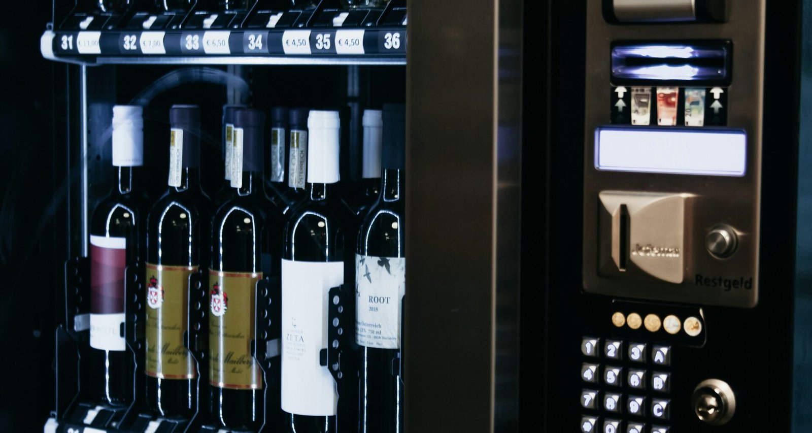 Ein moderner Weinautomat mit zahlreichen unterschiedlichen Weinflaschen, ordentlich in Reihen angeordnet.
