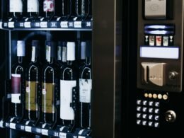 Ein moderner Weinautomat mit zahlreichen unterschiedlichen Weinflaschen, ordentlich in Reihen angeordnet.