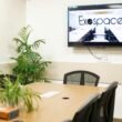 Ein heller, moderner Meetingraum mit großem Tisch und Exospace Logo an der Wand im Hintergrund.