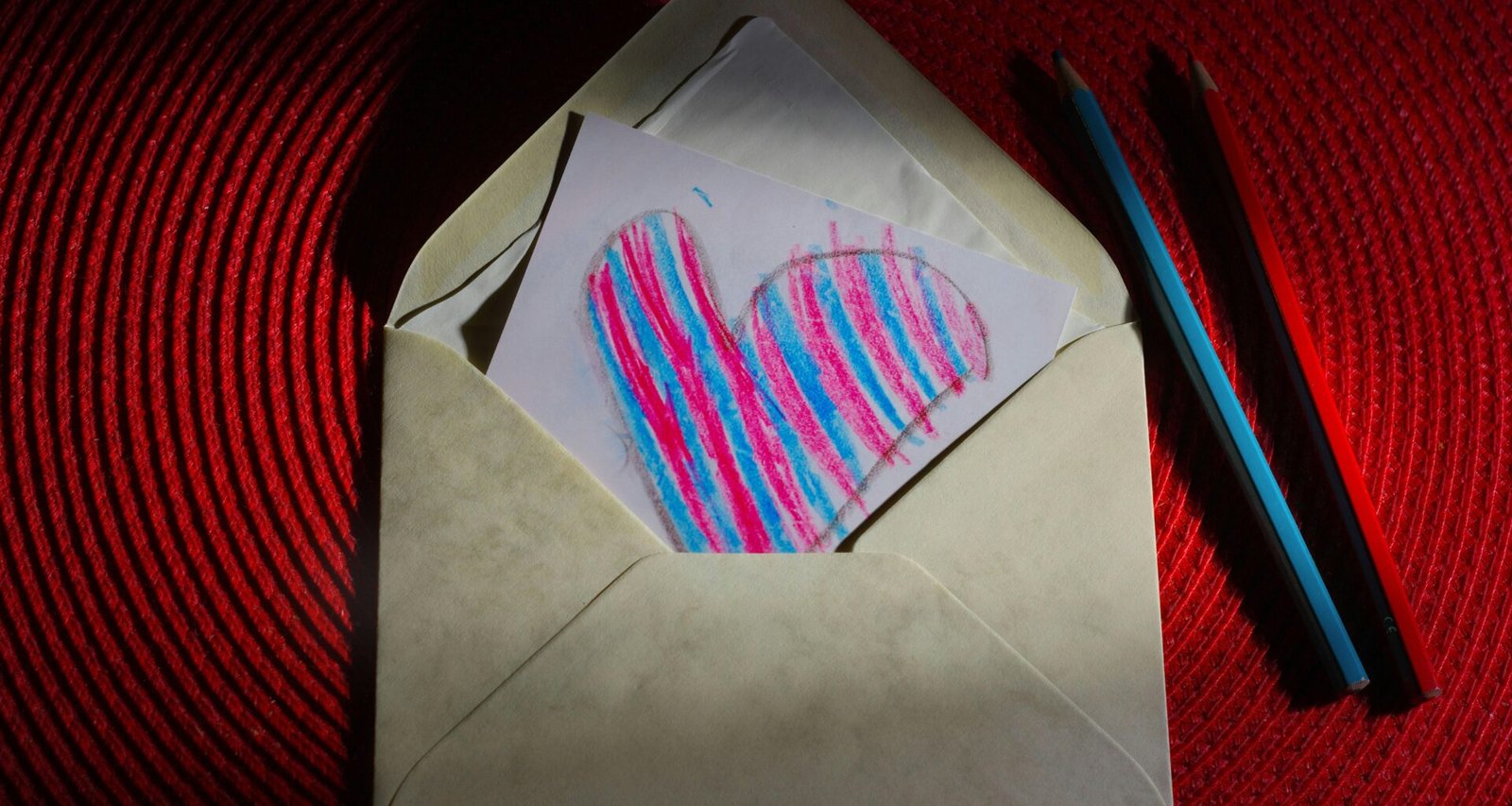 Ein weißes Stück Papier mit einem schwarzem Herz darauf, flach auf eine helle Oberfläche gelegt