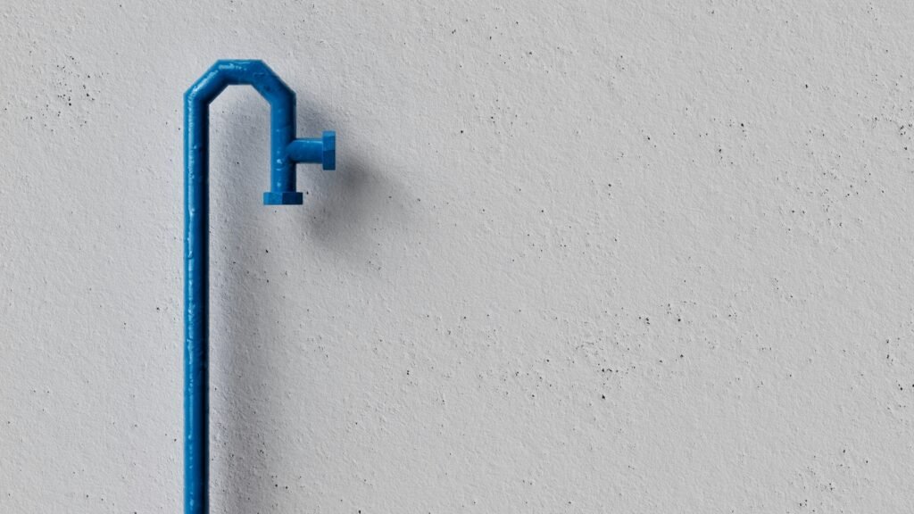 Blauer Türgriff aus Metall auf einer weißen Wand vor schlichtem Hintergrund, minimalistisches Design