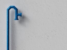 Blauer Türgriff aus Metall auf einer weißen Wand vor schlichtem Hintergrund, minimalistisches Design
