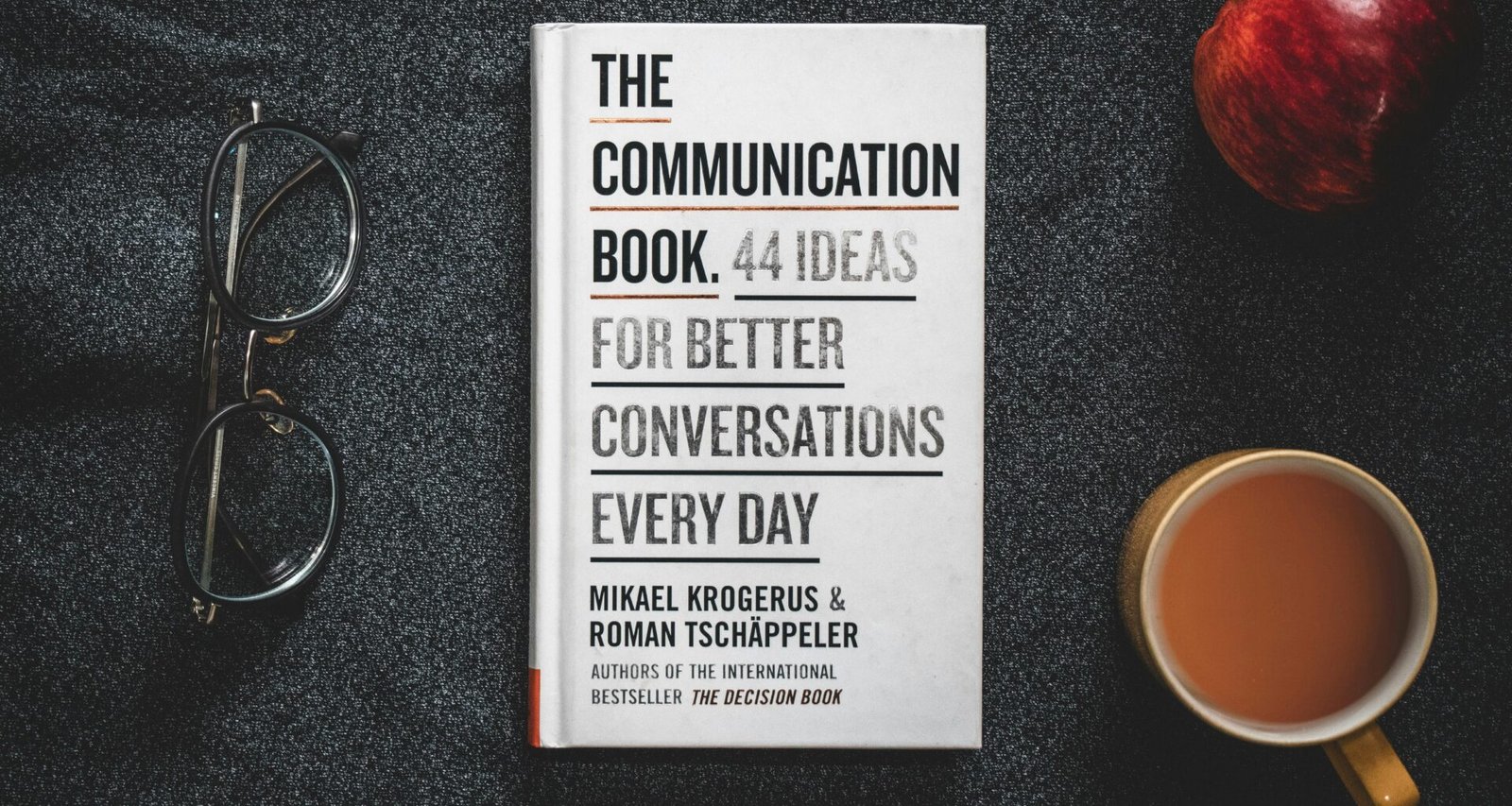 Ein Buch liegt auf einem Tisch neben einer Tasse Kaffee – idealer Arbeitsplatz für konzentriertes Lesen oder Lernen.
