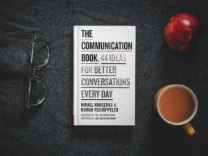 Ein aufgeschlagenes Buch auf einem Tisch neben einer Tasse Kaffee, ideale Umgebung zum Lesen oder Arbeiten