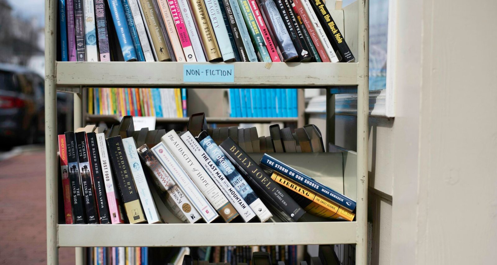 Ein großes Bücherregal mit vielen unterschiedlich gefüllten Regalbrettern, fotografiert in Innenraum.