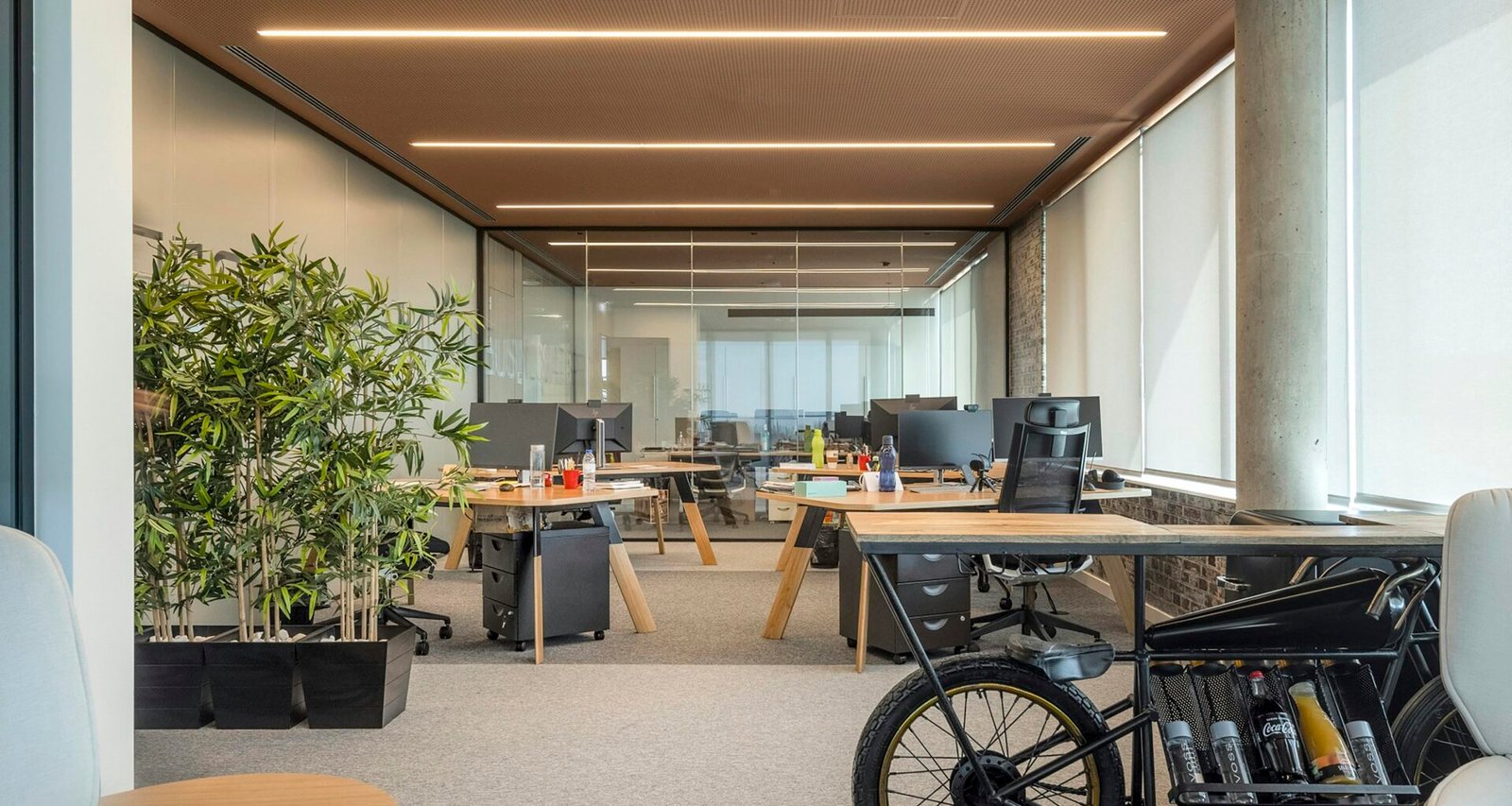 Helles Büro mit einem Fahrrad, das mittig im Raum geparkt ist, umgeben von modernen Möbeln und Arbeitsplätzen