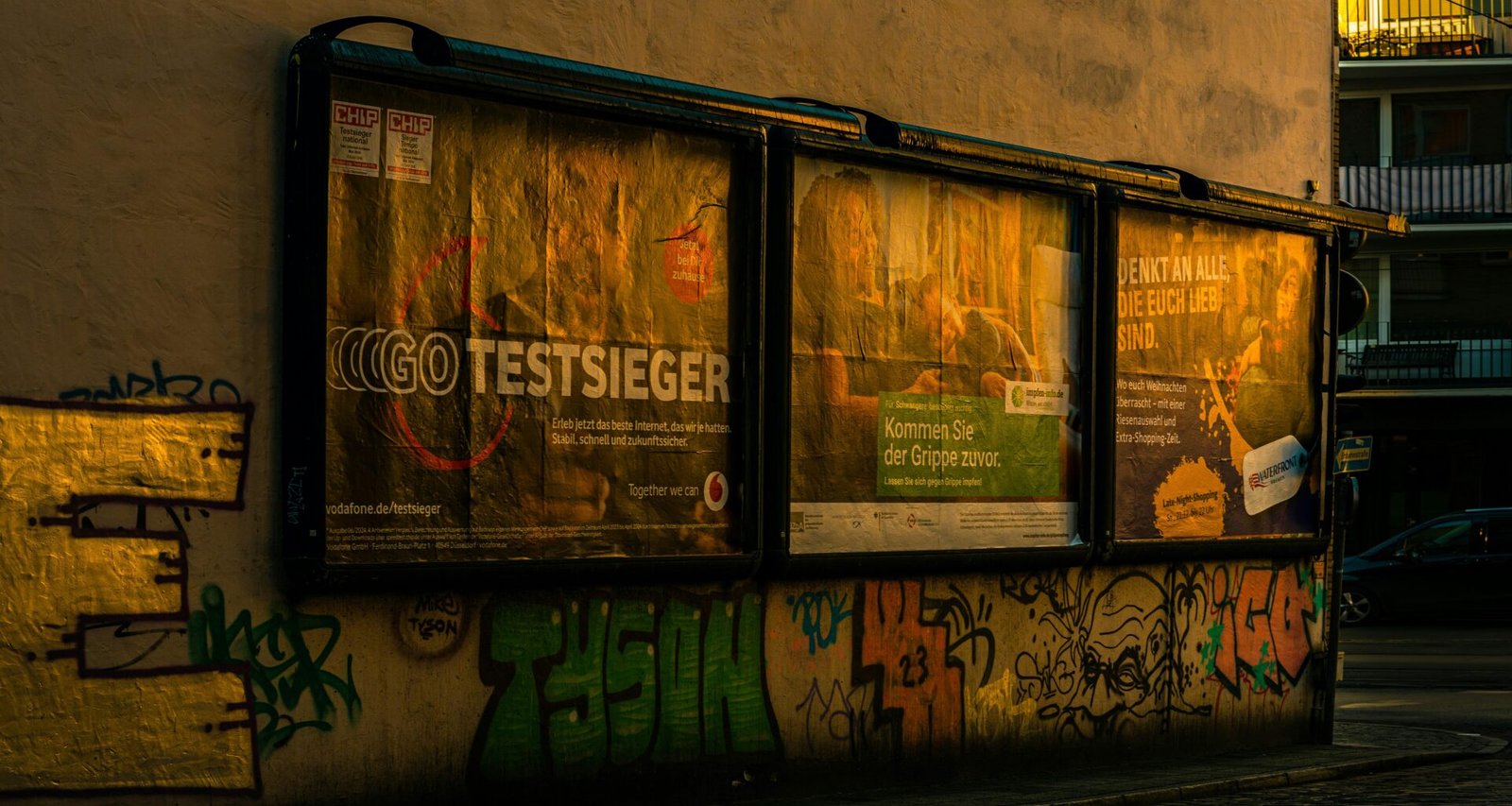 Ein geparkter Bus vor einem Gebäude mit bunter Graffiti-Kunst an der Fassade im urbanen Umfeld