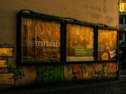 Ein geparkter Bus vor einem Gebäude mit bunter Graffiti-Kunst an der Fassade im urbanen Umfeld