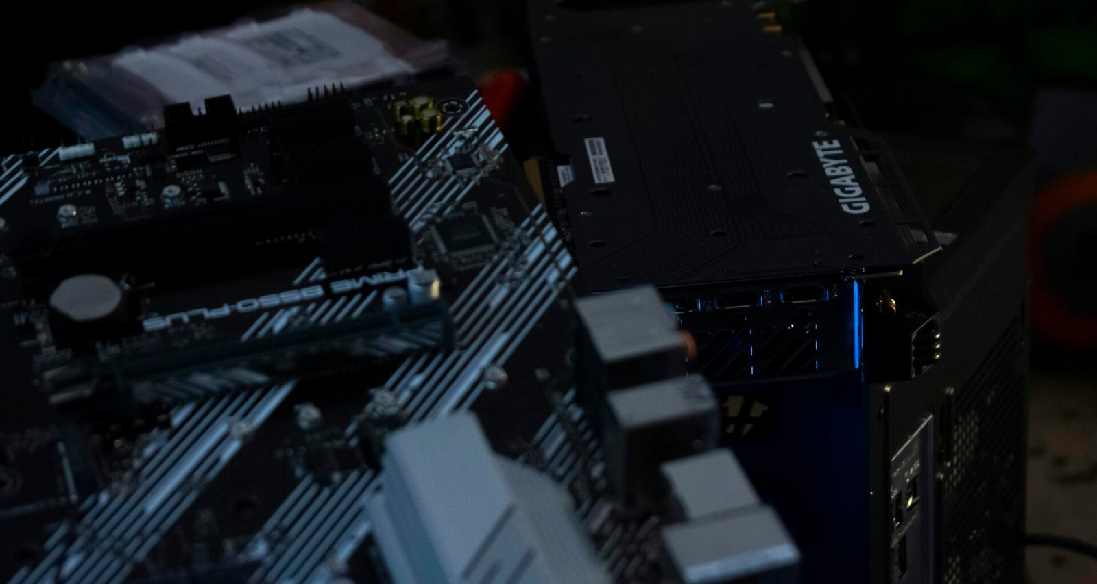 Detailansicht eines Computer-Motherboards mit installierter Grafikkarte und sichtbaren elektronischen Bauteilen.