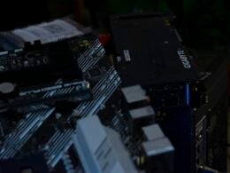 Detailansicht eines Computer-Motherboards mit installierter Grafikkarte und sichtbaren elektronischen Bauteilen.