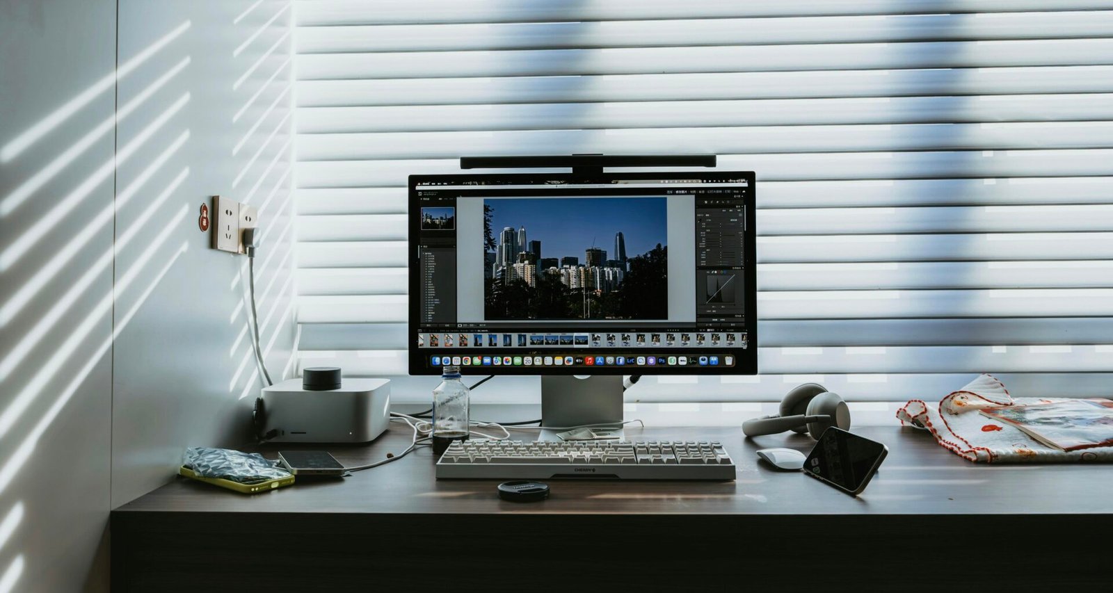 Computerarbeitsplatz mit Monitor, auf dem eine Stadtsilhouette zu sehen ist, auf einem Schreibtisch in moderner Umgebung