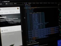 Ein Computerbildschirm mit zahlreichen Code- und Textzeilen, aufgenommen in einer modernen Büroumgebung.