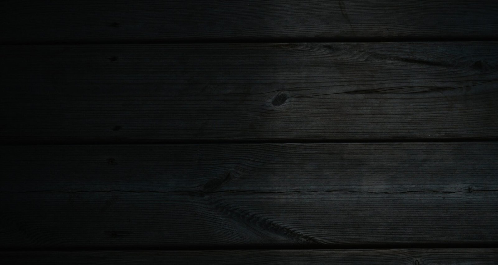 Dunkler Holzhintergrund mit schwarzem Hintergrund, ideal als dezente Textur für Webseiten oder Online-Marketing-Projekte