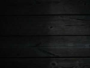 Dunkler Holzhintergrund mit schwarzem Hintergrund, ideal als dezente Textur für Webseiten oder Online-Marketing-Projekte