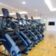Ein gym mit verschiedenen Trainingsgeräten, Hanteln und Laufbändern in einem modernen, gut beleuchteten Raum