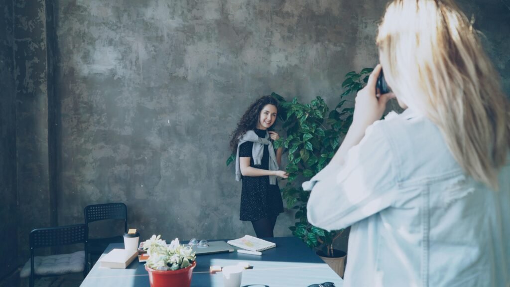 Ein Fotograf richtet seine Kamera auf ein Model und bereitet eine Aufnahme für ein Fotoshooting vor