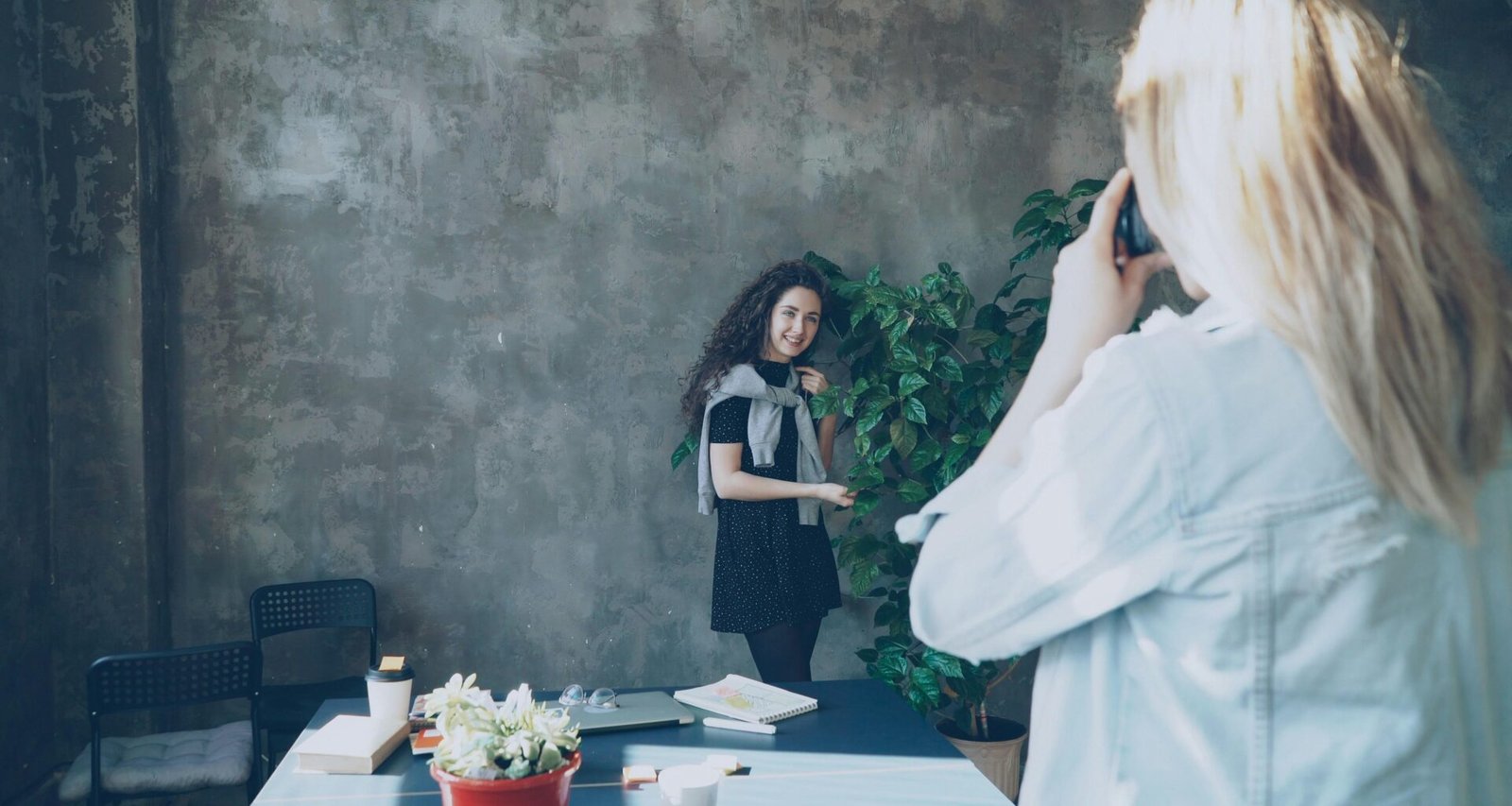 Ein Fotograf richtet seine Kamera auf ein Model und bereitet eine Aufnahme für ein Fotoshooting vor