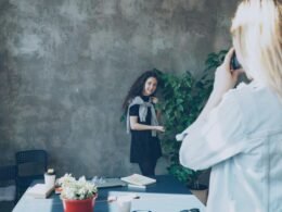 Ein Fotograf richtet seine Kamera auf ein Model und bereitet eine Aufnahme für ein Fotoshooting vor