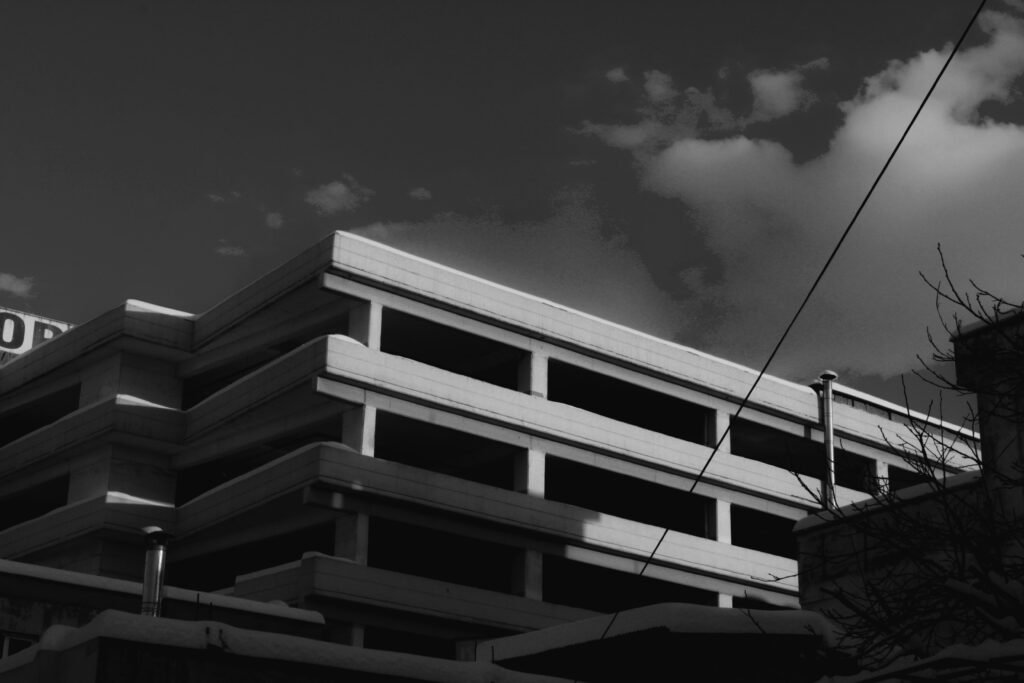 Ein modernes Gebäude vor einem bewölkten Himmel, aufgenommen aus Bodensicht; der Fokus liegt auf Architektur und Struktur.