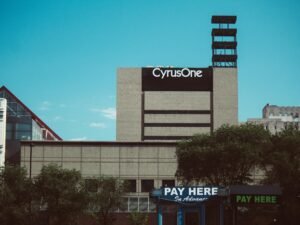 Modernes Gebäude mit großer "Pay Here"-Beschilderung auf dem Dach, Sinnbild für digitale Zahlungsoptionen in Städten