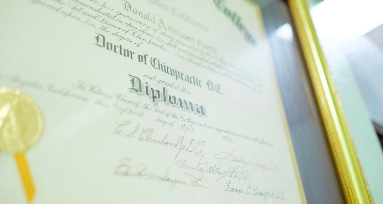 Ein gerahmtes Diplom mit goldenem Siegel liegt auf einer hellen Oberfläche und steht für Bildungserfolg und Zertifizierung.